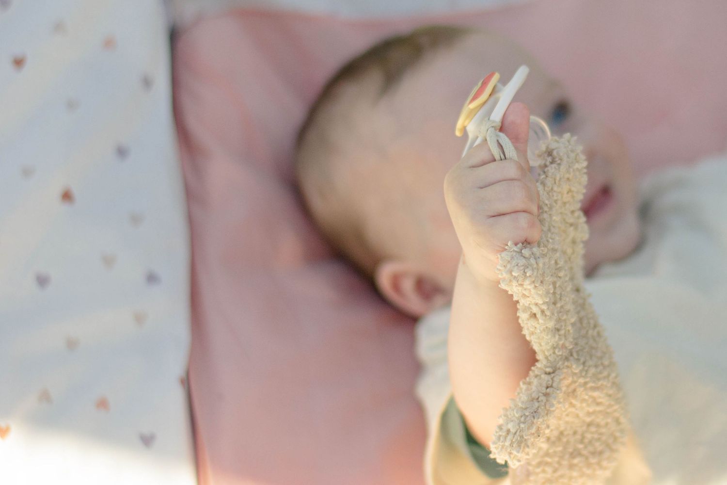 Portrait couleur naissance, le bébé tient son hochet et regarde hors cadre