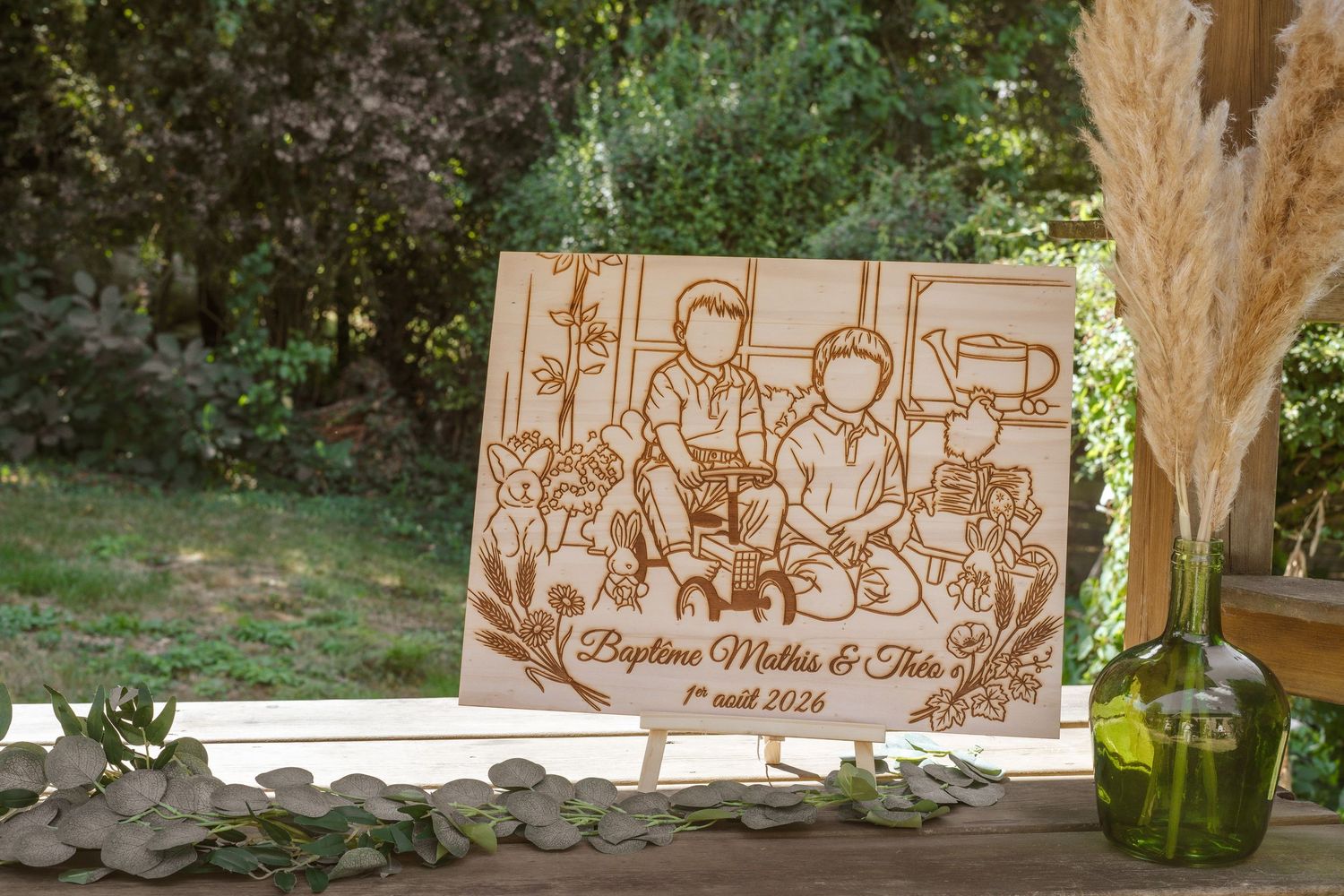Livre d'or de mariage personnalisé en bois gravé au laser avec le portrait du couple et leurs noms, exposé à l'extérieur sur une table