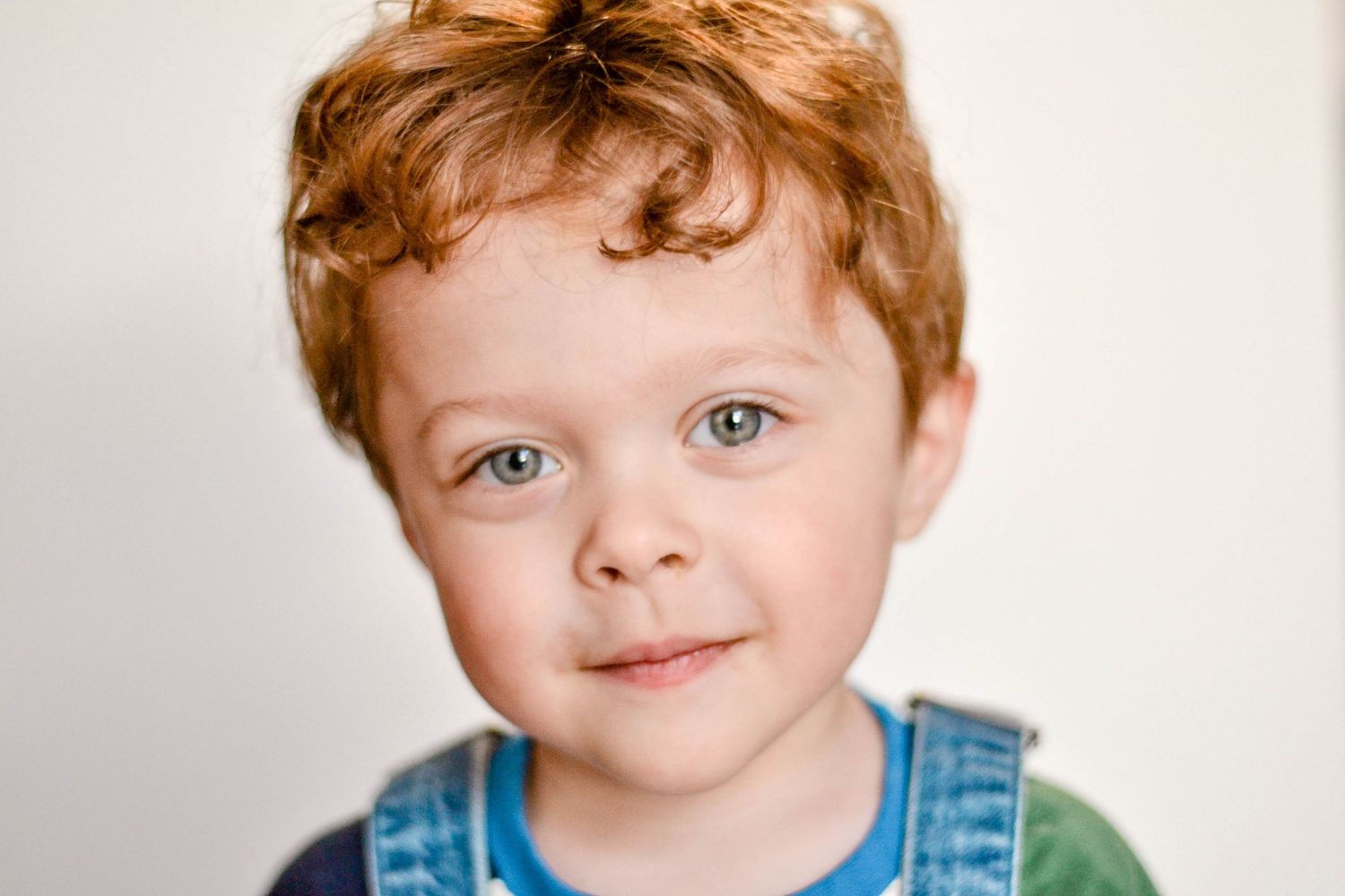 Portrait couleur d'un enfant roux aux yeux clairs fixant l'objectif, capté à Ronchin