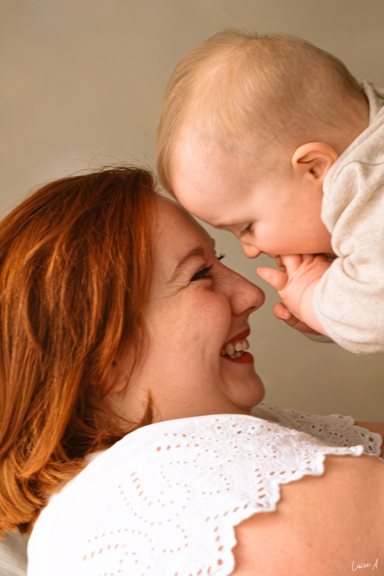 Une maman rousse rayonnante, souriant face à face avec son bébé heureux, partageant un tendre moment nez à nez.