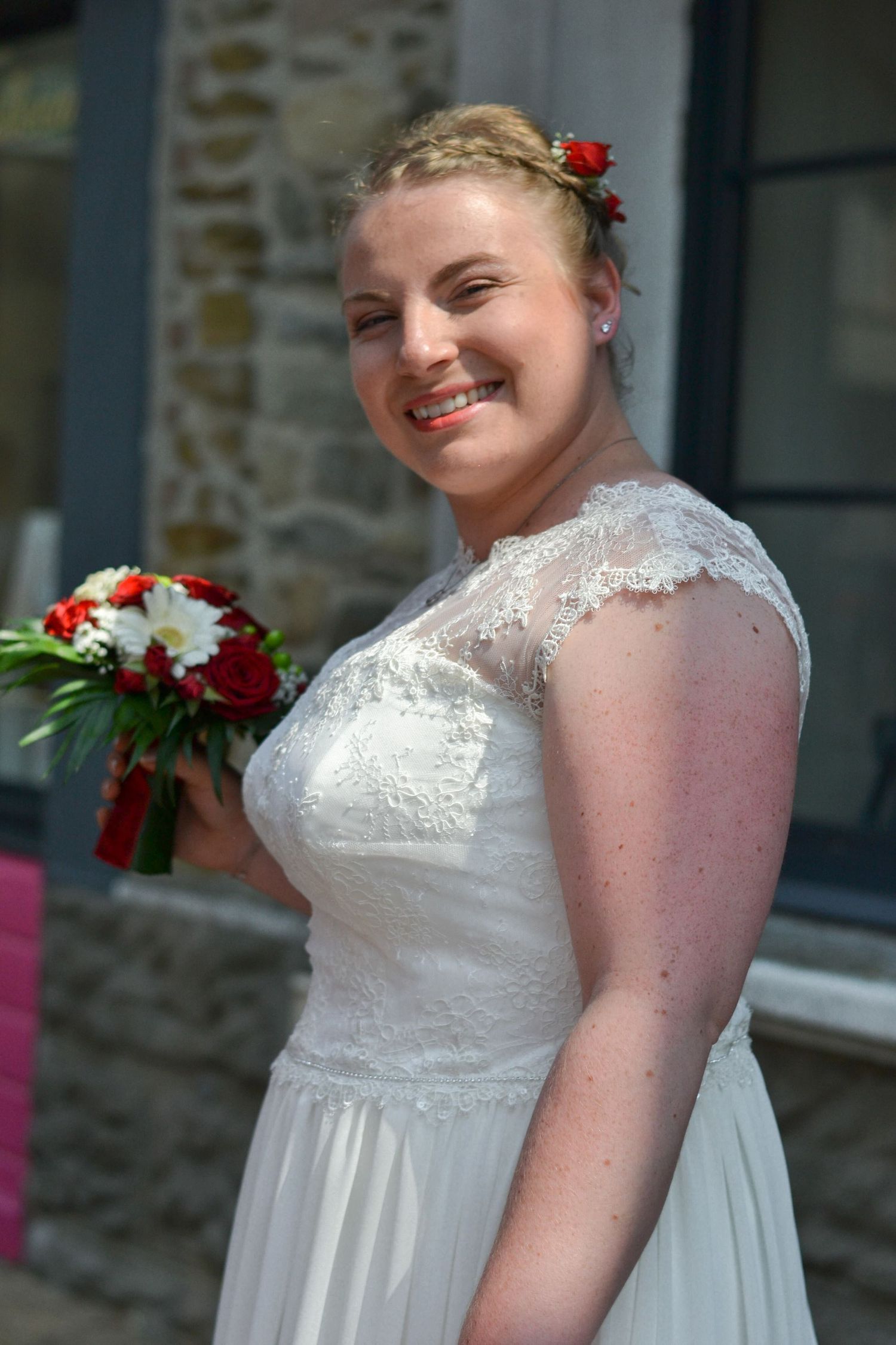 Portrait couleur d'une jeune mariée de profil en robe tenant son bouquet, séance mariage à Lille