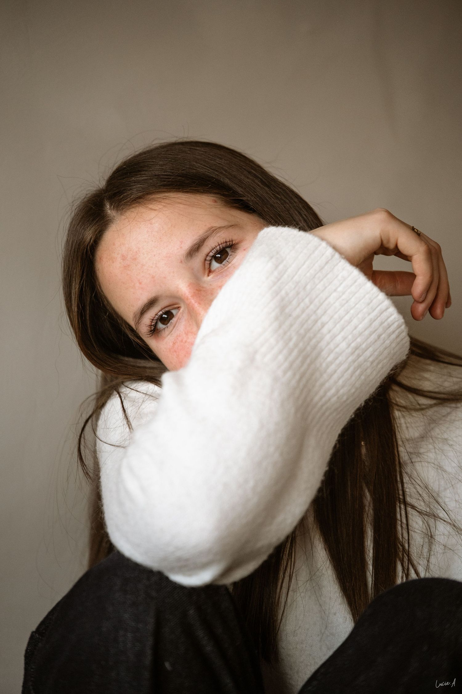 Portrait d’une femme en pull clair, posant en intérieur avec un regard doux – séance photo à Ronchin près de Lille