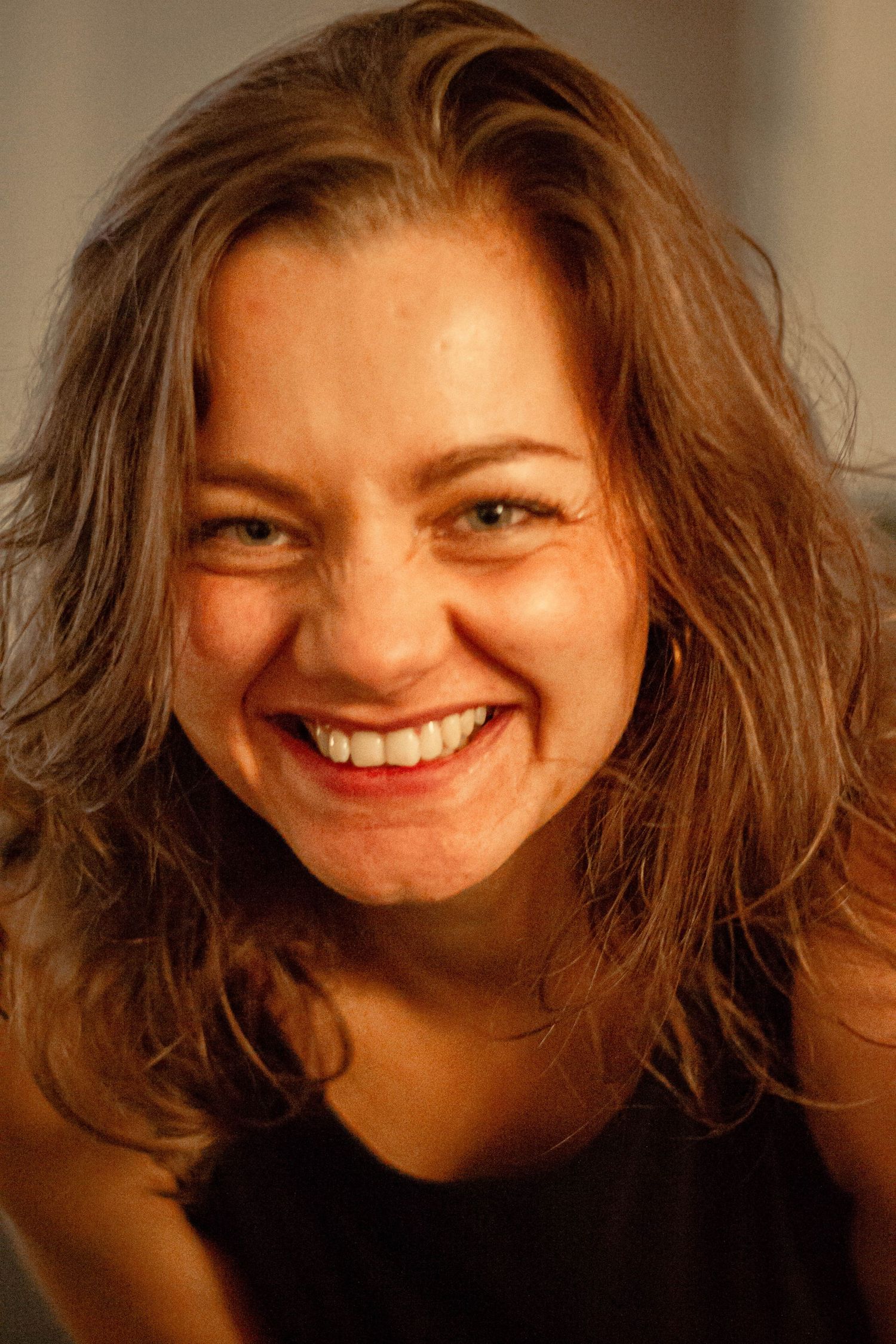 Portrait couleur d'une femme souriant et se penchant en avant, prise à Ronchin