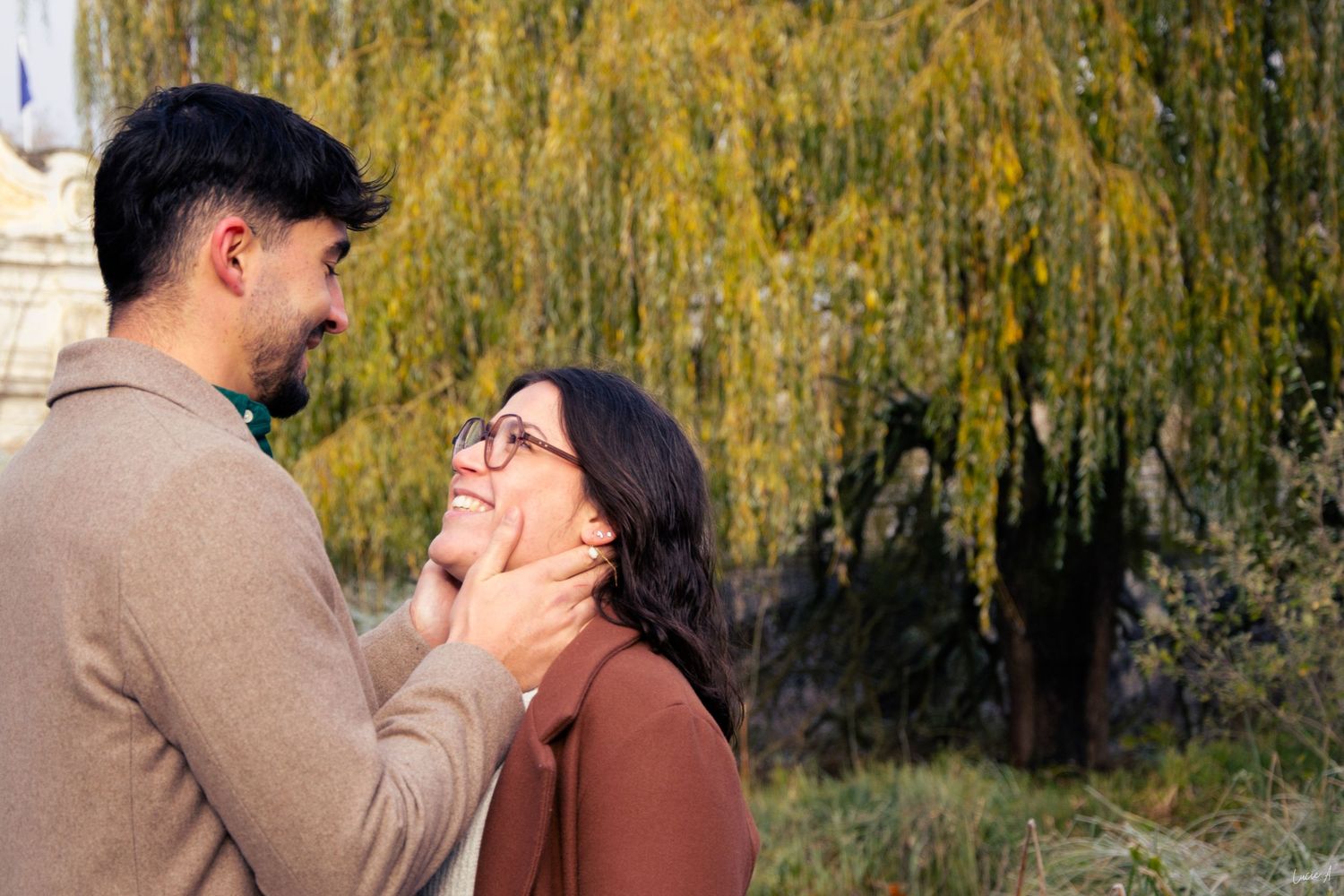 Portrait couleur prise large lors d'une séance d'engagement, le couple se regarde, l'homme posant ses mains sur son visage, capté à Lille
