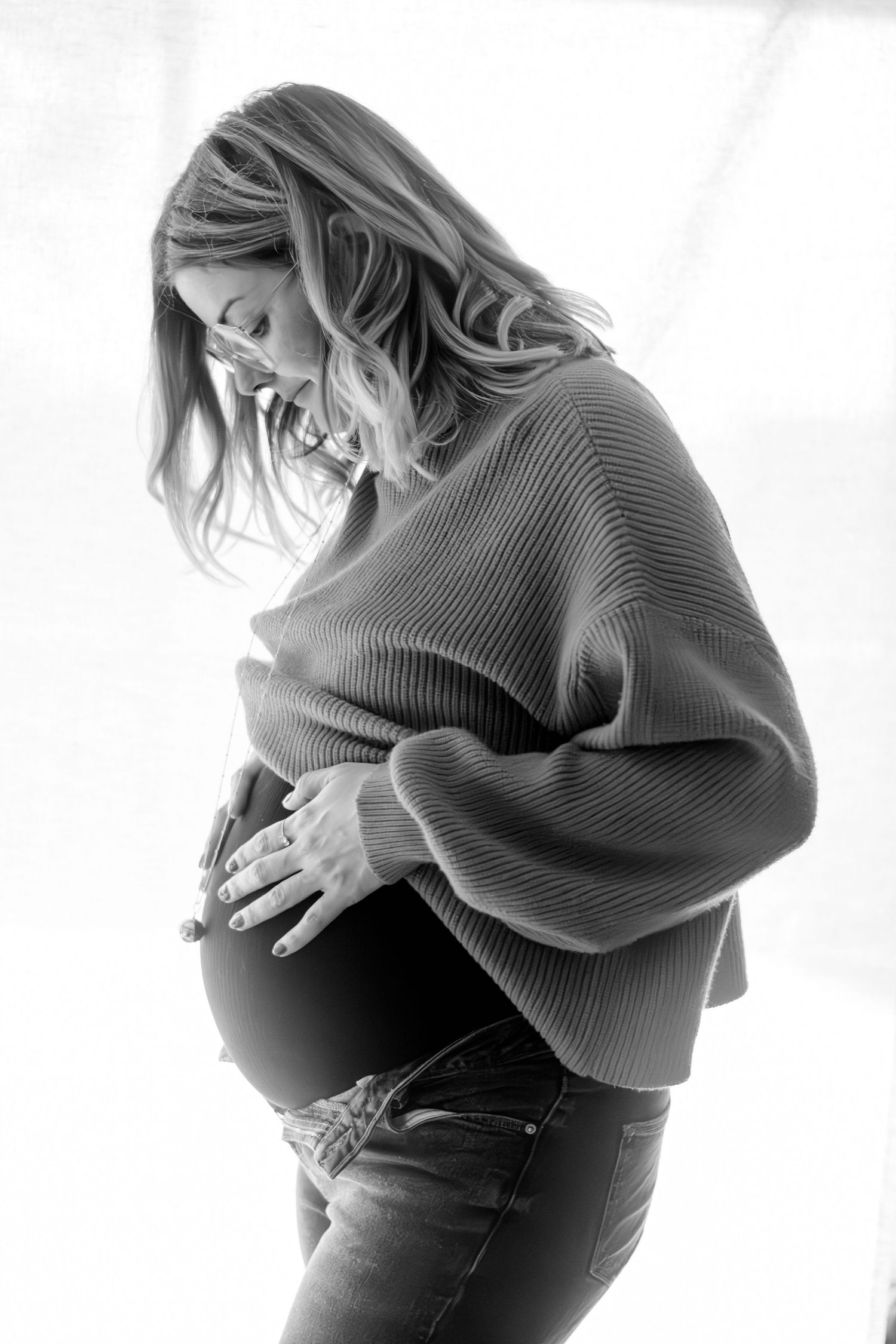 Portrait noir et blanc séance grossesse, femme enceinte de profil à contre jour, capté à Ronchin près de Lille