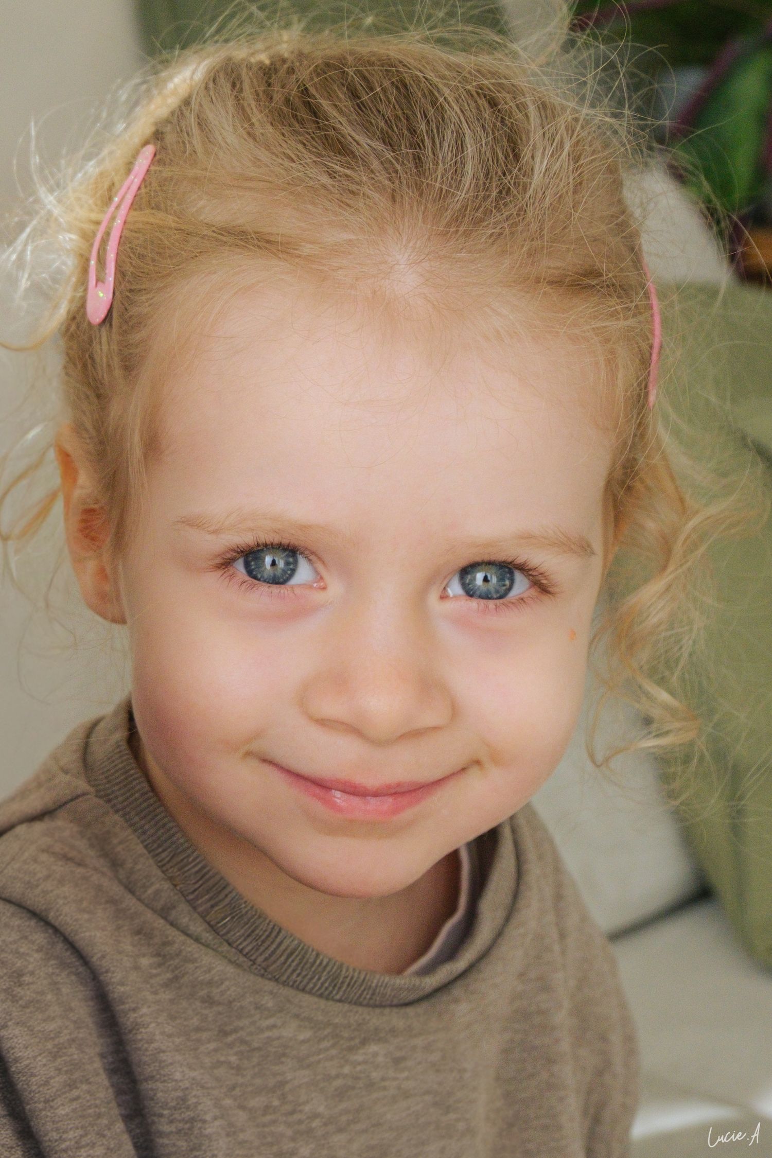 portrait d'un jeune enfant blonde au yeux bleus regardant la caméra