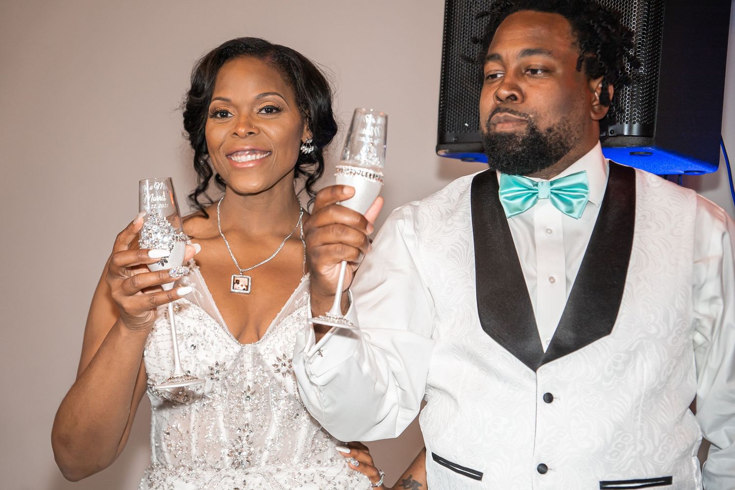 Bride and groom toast with champagne glasses at wedding reception celebration.