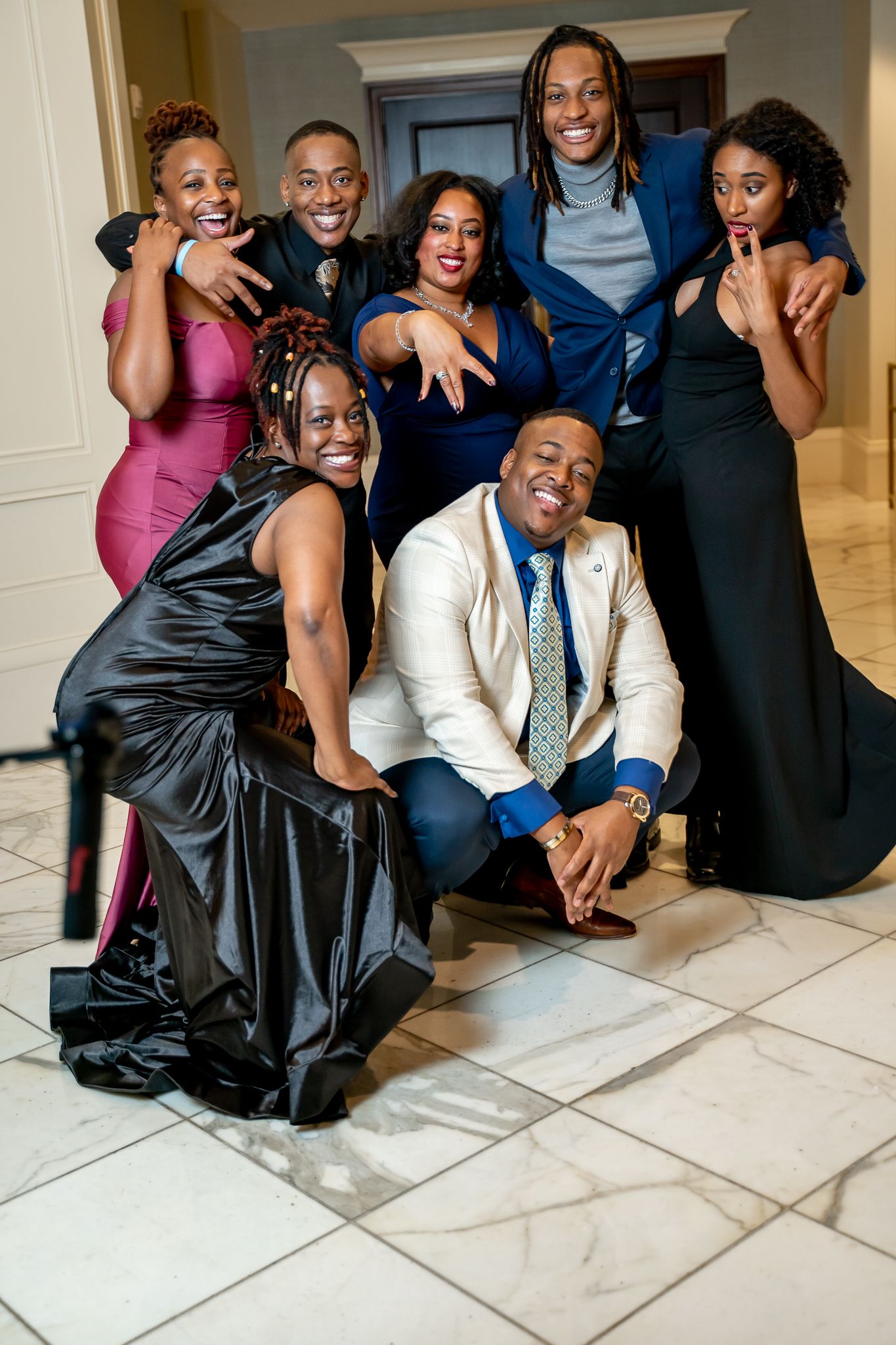 Stylish group of friends in formal wear posing together at an elegant venue.