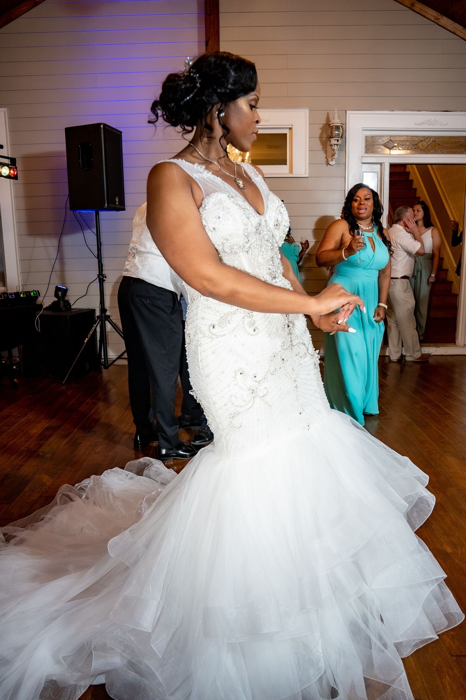 Bride in white mermaid gown shares first dance at wedding reception.