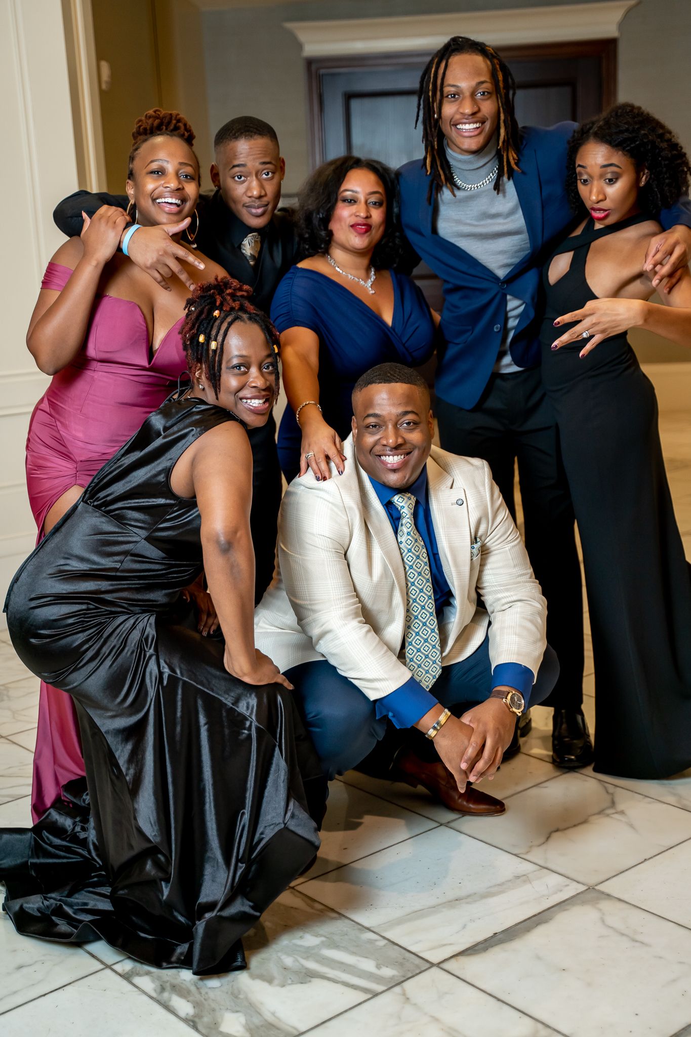 Well-dressed group of friends smiling and posing together at a formal event.
