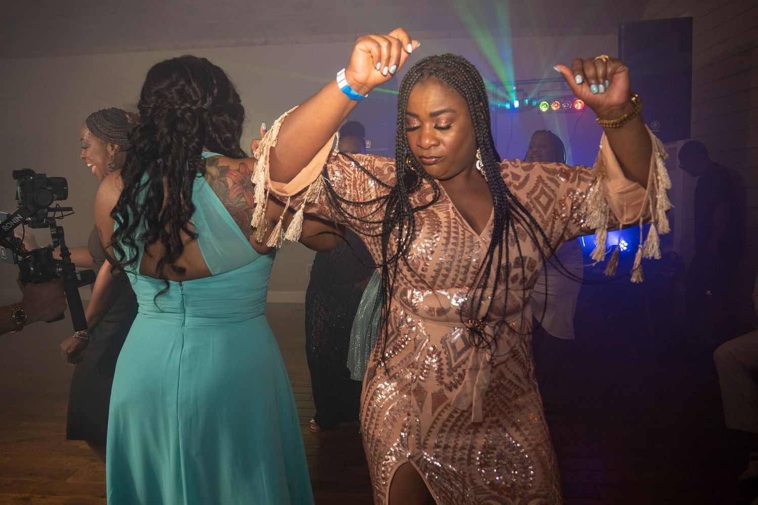 Guest in sequined dress dances energetically at lively wedding reception.