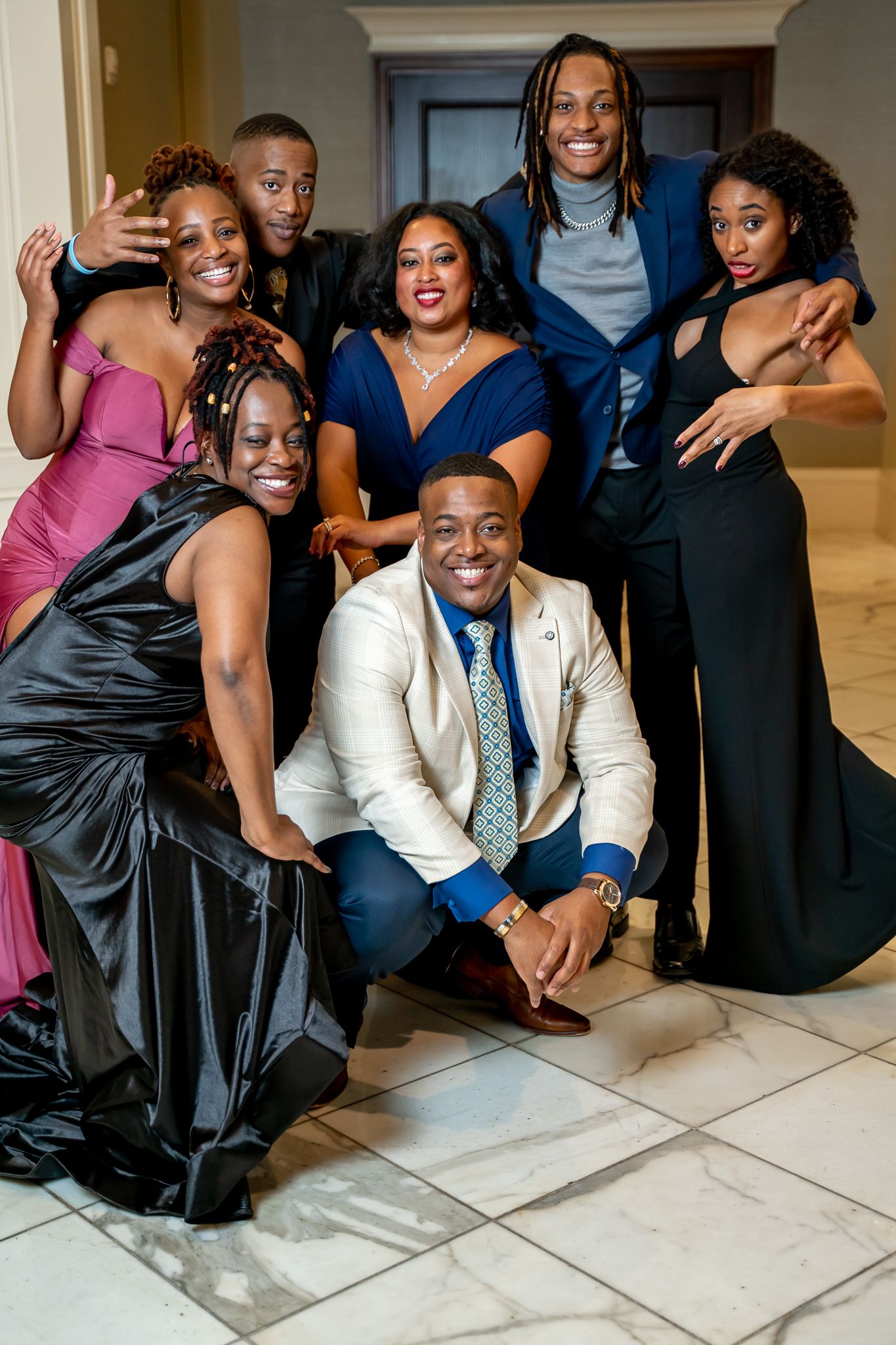 Smiling group of elegantly dressed friends posing together at a formal occasion.