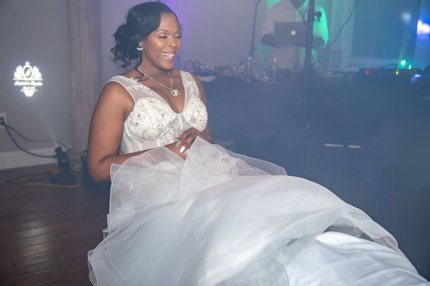 Bride in white ball gown dancing joyfully on the dance floor at her wedding reception.