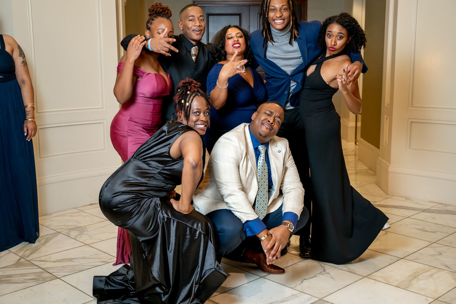 Smiling group of friends in formal wear posing together at a special event.
