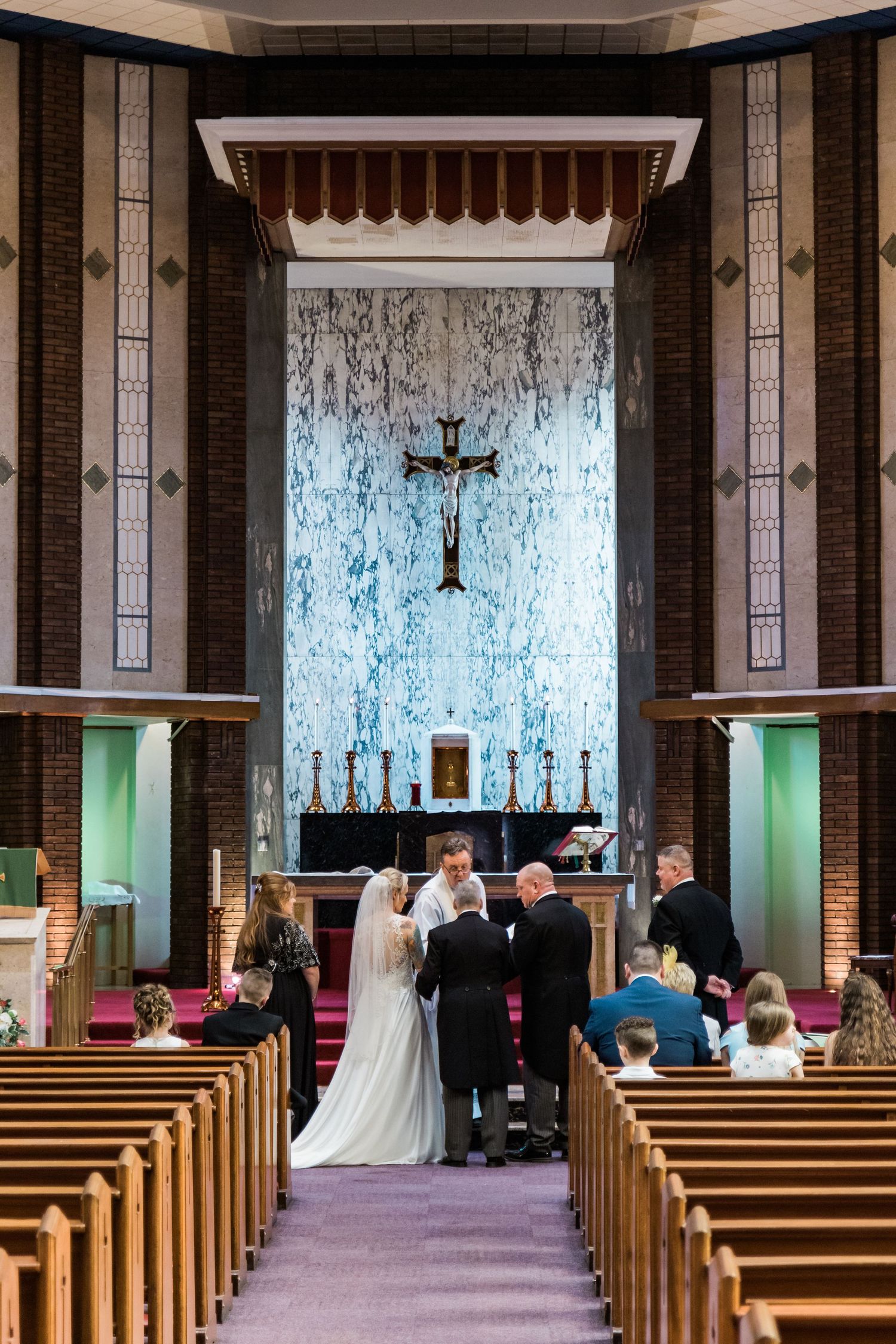 Wedding ceremony at the altar inside a church with family and guests witnessing the moment