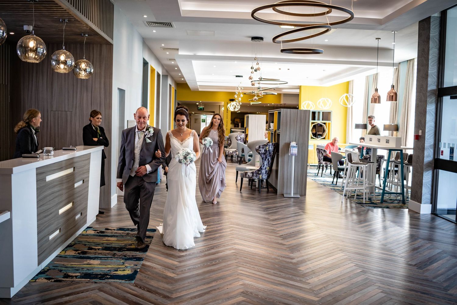 Father of the bride walks her into Holiday Inn Washington UK, a modern North East wedding venue with stylish interiors and elegant event spa