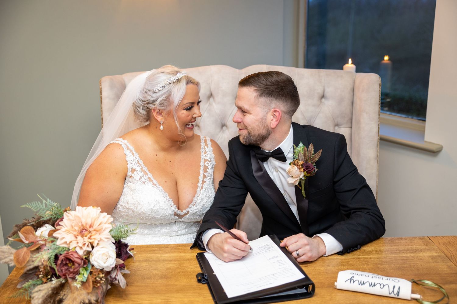 Bride and groom signing register at The Woodman's Arms & The Willows, romantic ceremony moment with elegant decor