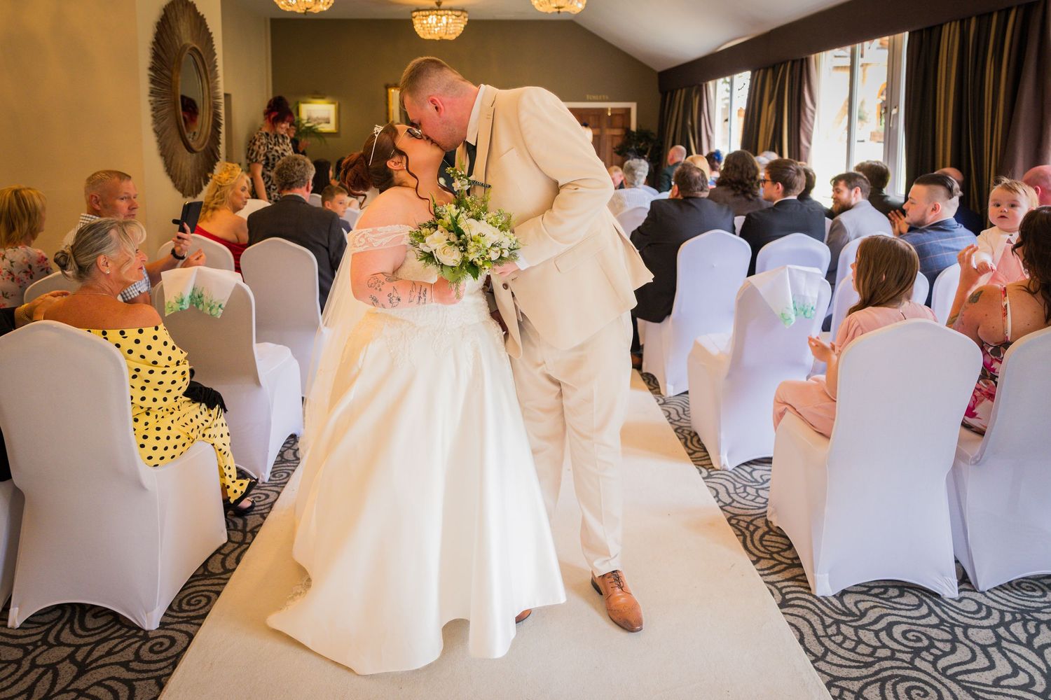 Bride and groom kissing on the dance floor at Ramside Hall in County Durham as their wedding guests watch.