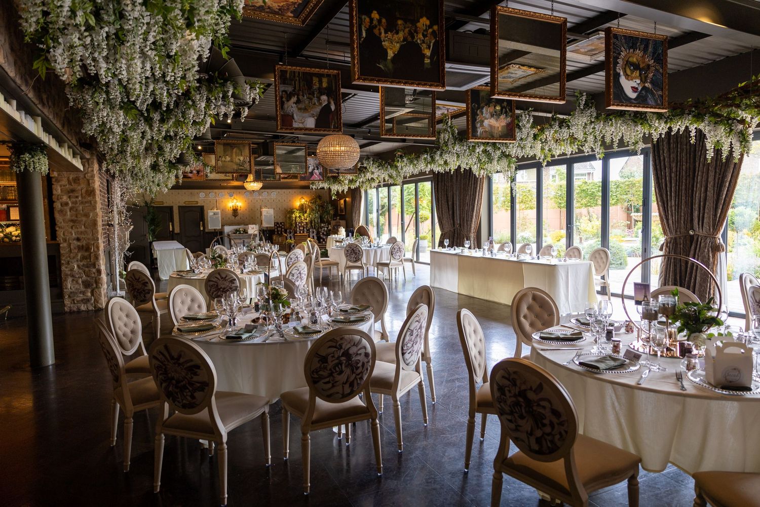 Reception room at Bowburn Hall; elegant tables, floral décor, and greenery-filled ceiling create a romantic setting.