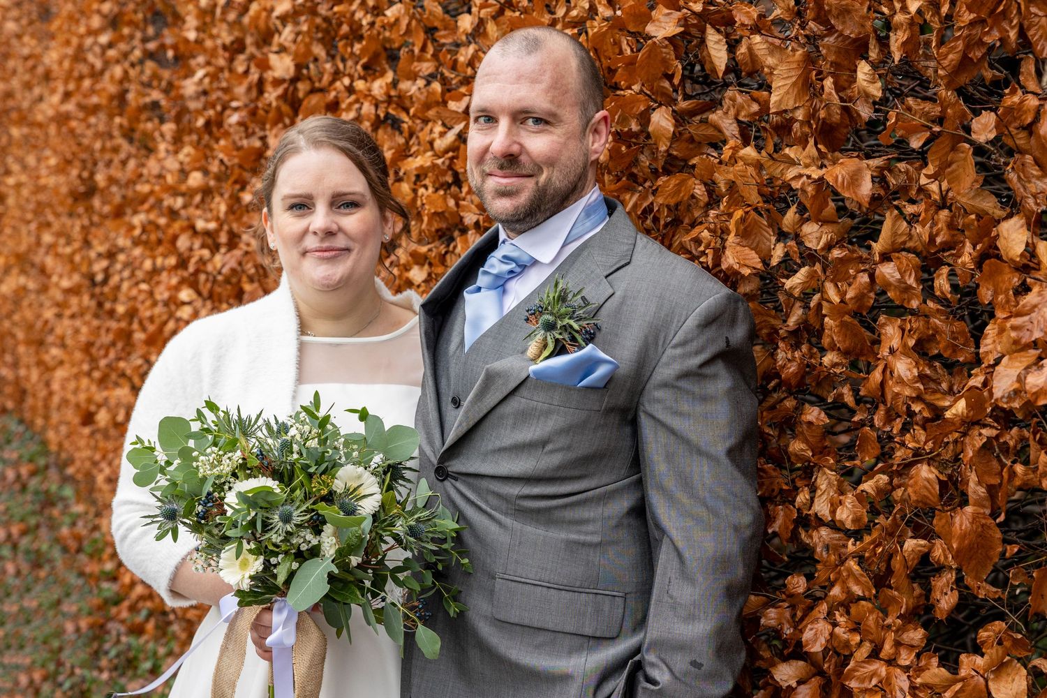 Couple at Lumley Castle in autumn; warm tones, leafy backdrop, and relaxed portrait.