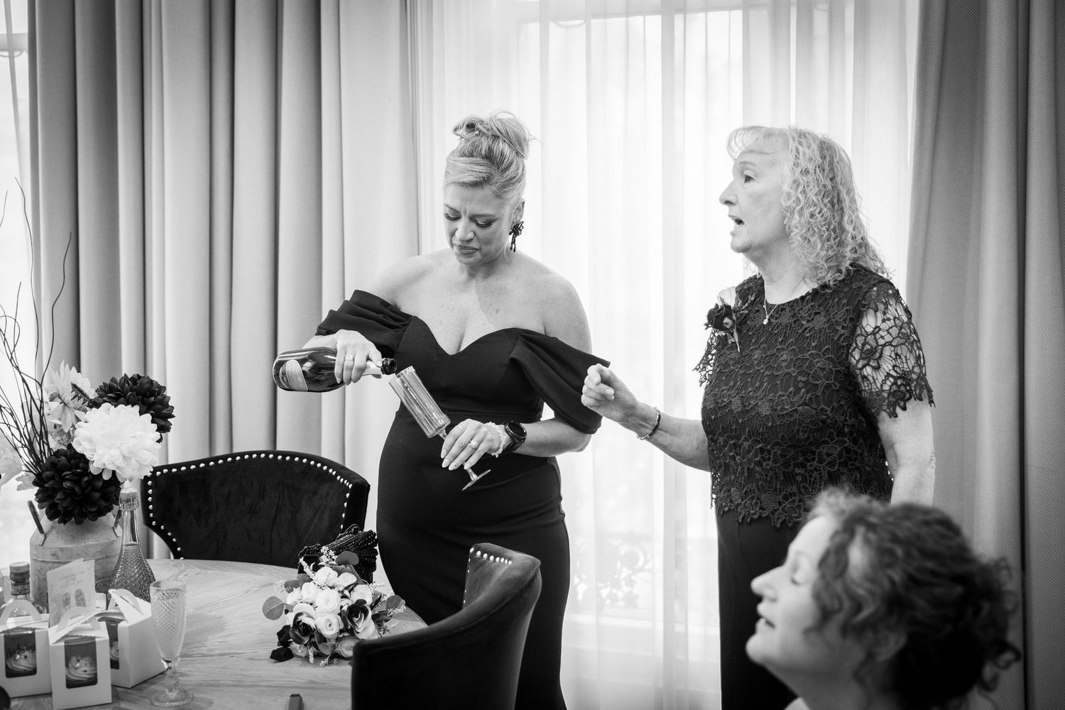 Getting ready at The County, Newcastle; candid moment as champagne is poured in black-and-white.
