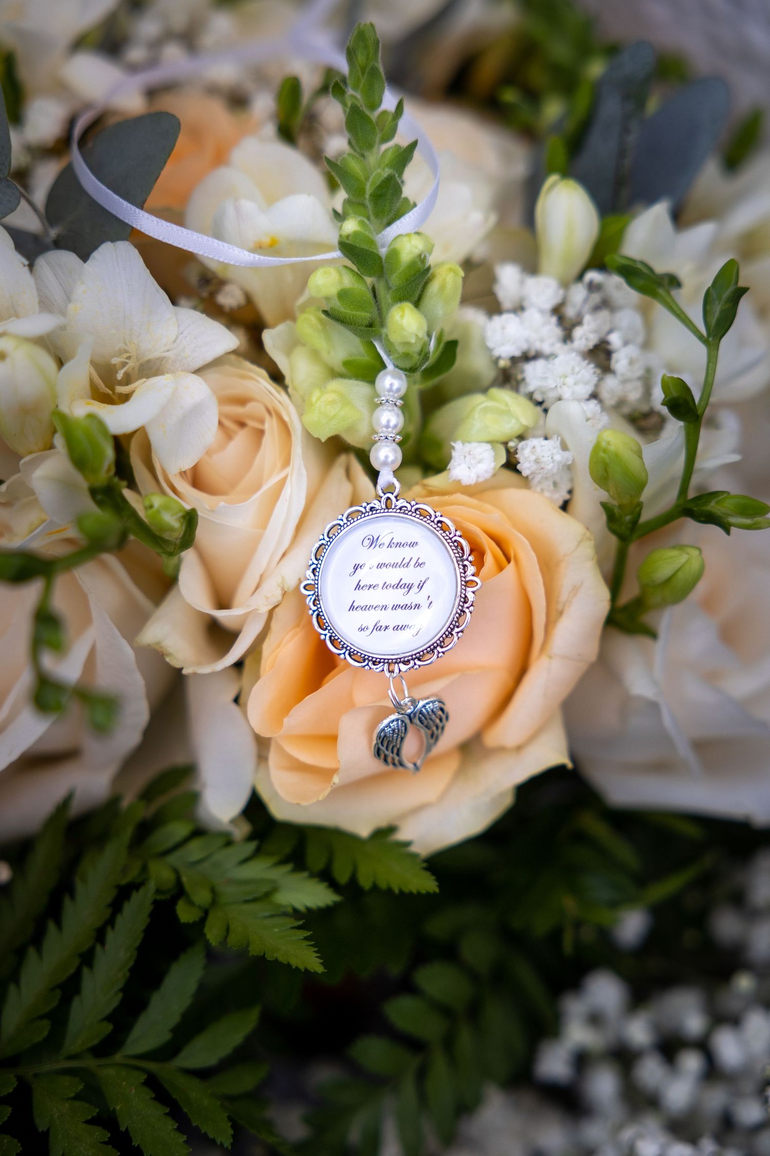 Wedding bouquet detail with memorial charm, sentimental tribute to loved one, soft floral arrangement, emotional and meaningful wedding phot