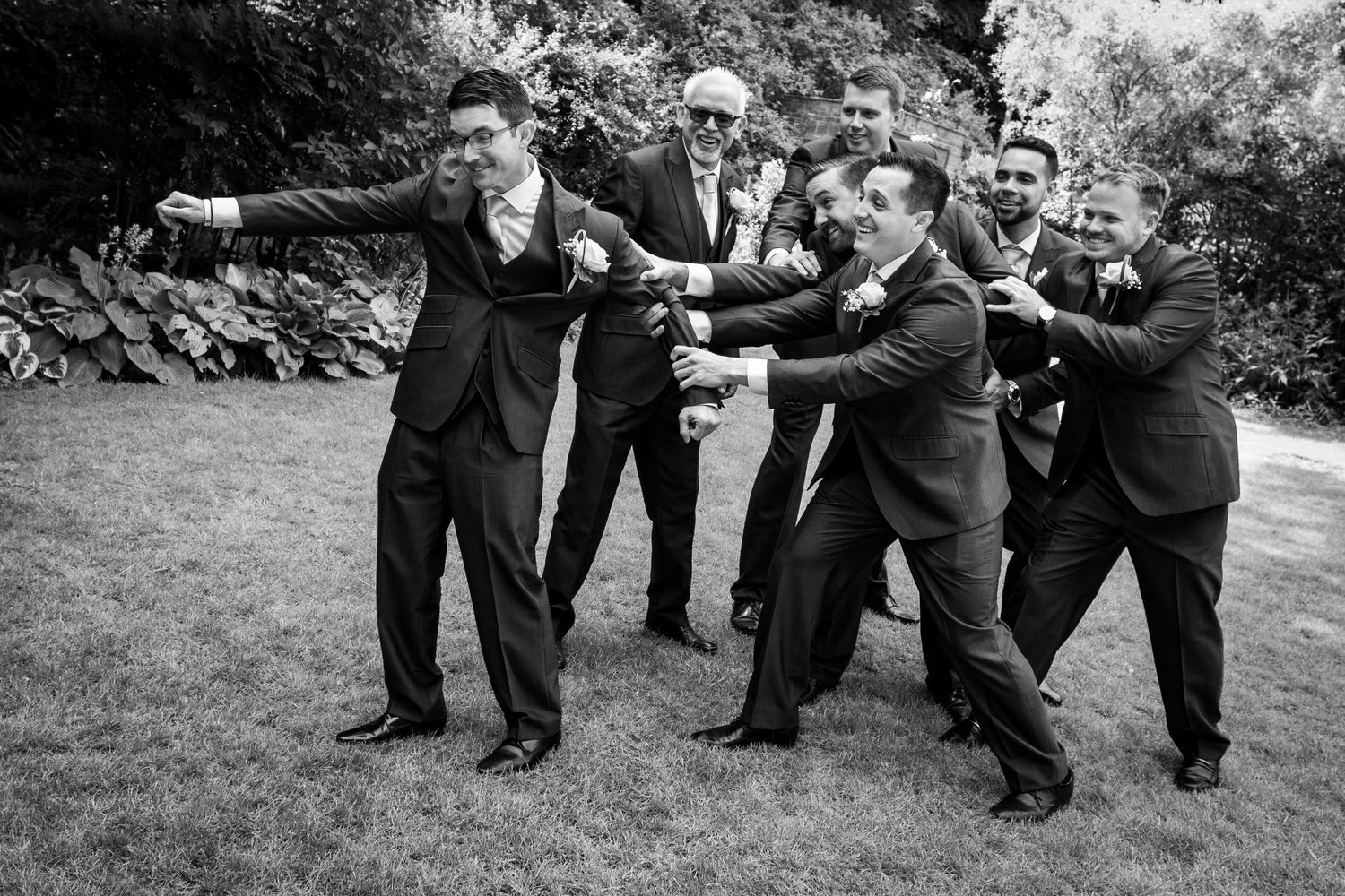 Fun groomsmen moment at Gosforth Hall Hotel, with the group joking and pulling the groom for a relaxed, candid wedding photo.