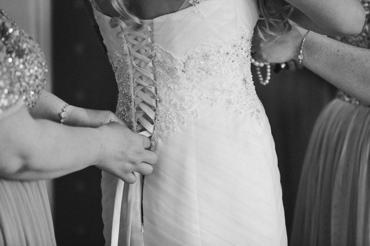 Bridal dress being laced up during preparations at Seaham Hall, capturing a timeless and intimate getting-ready moment.