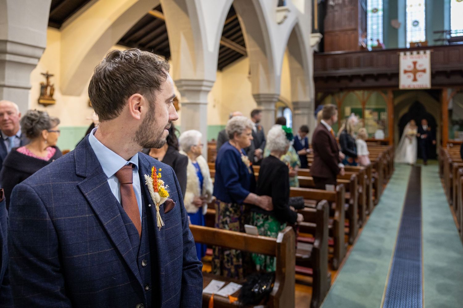 Groom waits at the altar as bride arrives in church, a beautiful wedding ceremony moment filled with anticipation, emotion and timeless trad