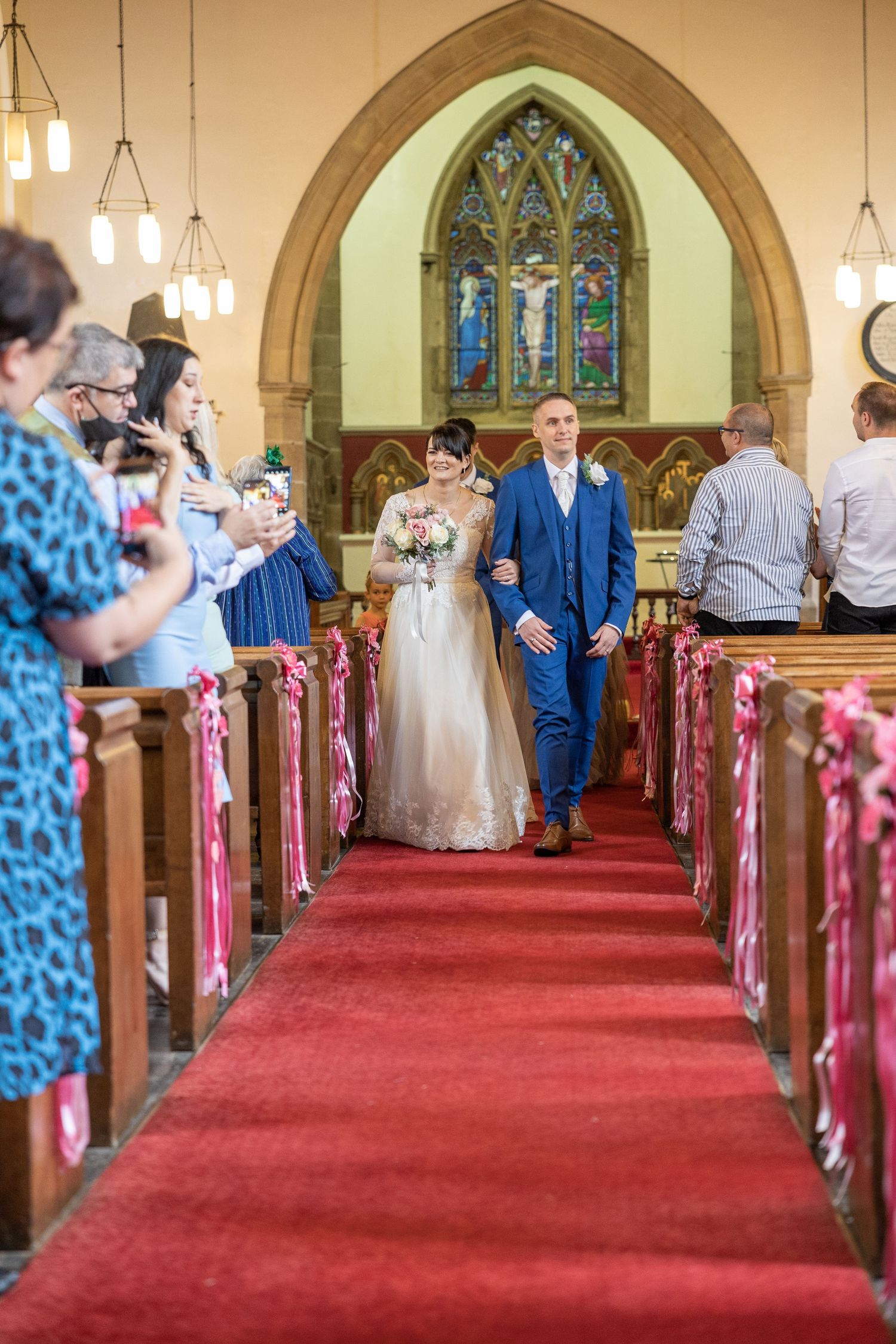 Newlyweds walking down the aisle after their wedding ceremony in a beautifully decorated church