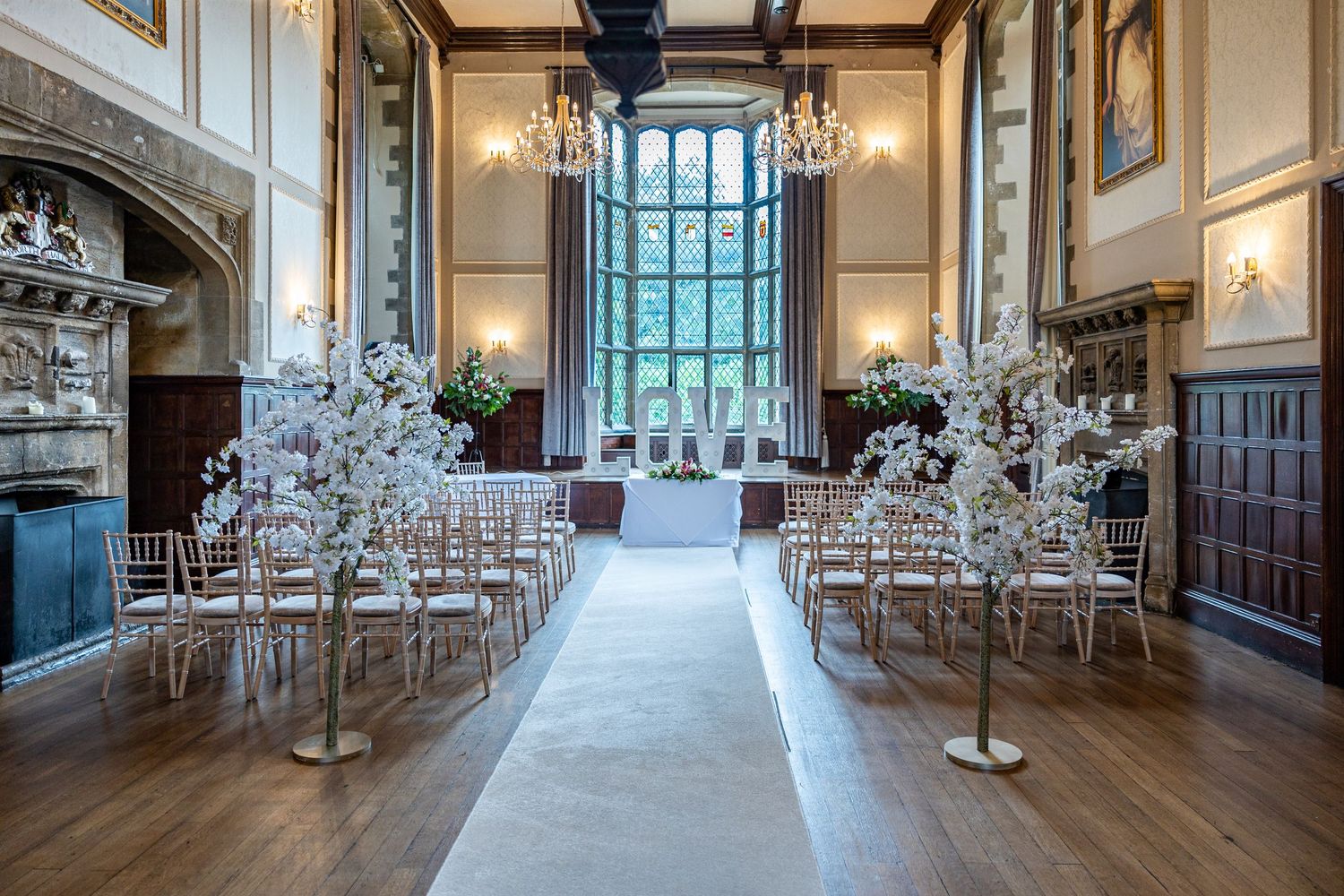 Elegant ceremony setup at Redworth Hall Hotel, a stunning historic wedding venue with chandeliers, floral aisle décor and timeless romance.