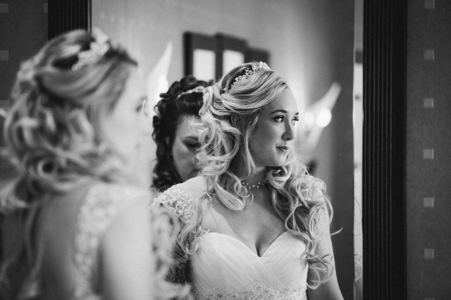 Bride getting ready at Seaham Hall, reflected in a mirror as final hair touches are made before the ceremony.