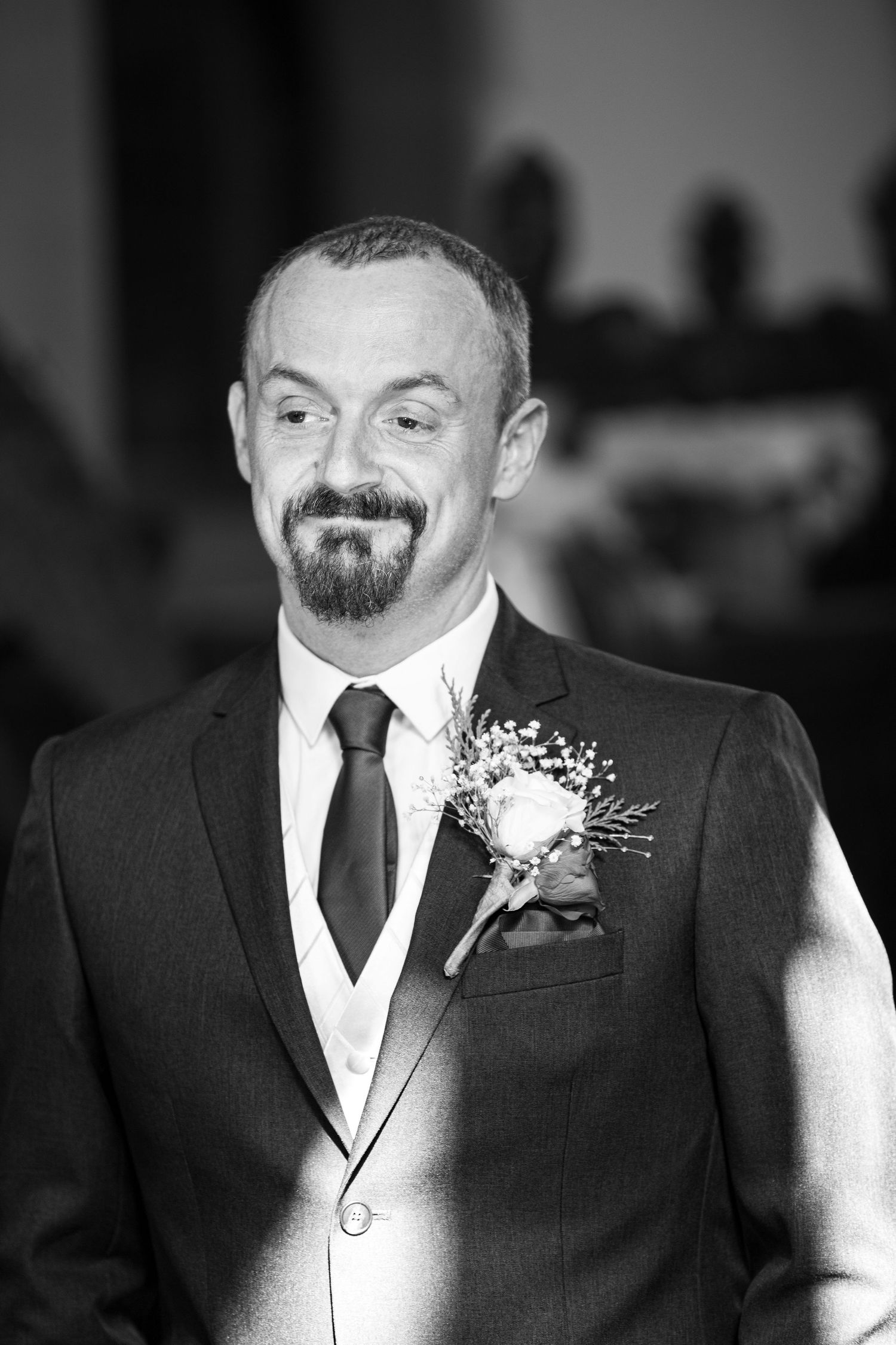 Groom smiles during wedding ceremony at North East UK venue, elegant black and white portrait capturing emotion and timeless style