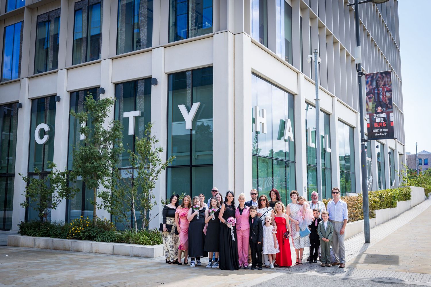 Wedding couple and guests posing outside Sunderland City Hall.