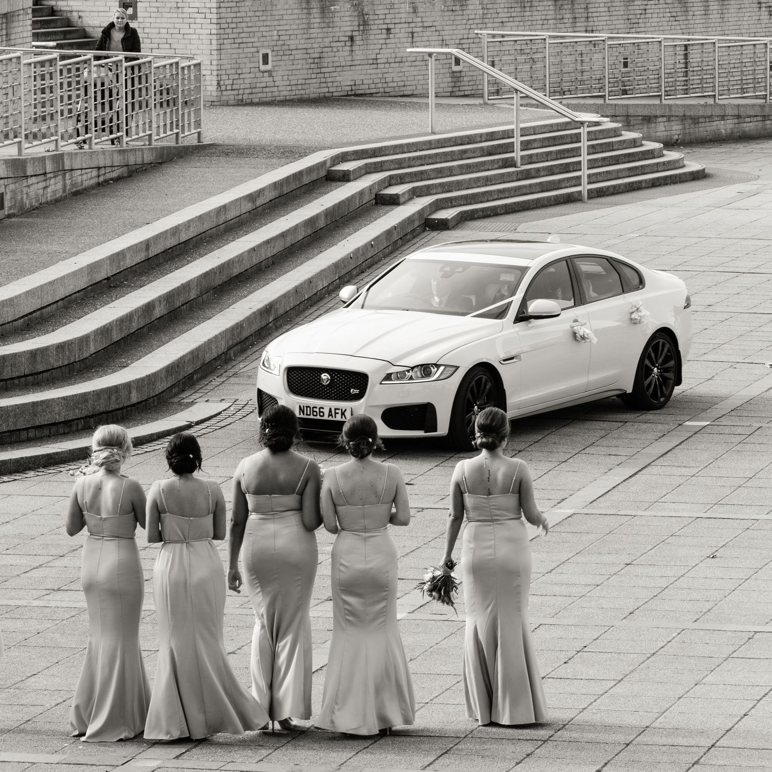 Bridesmaids walking towards a wedding car outside Baltic Centre for Contemporary Art in Newcastle