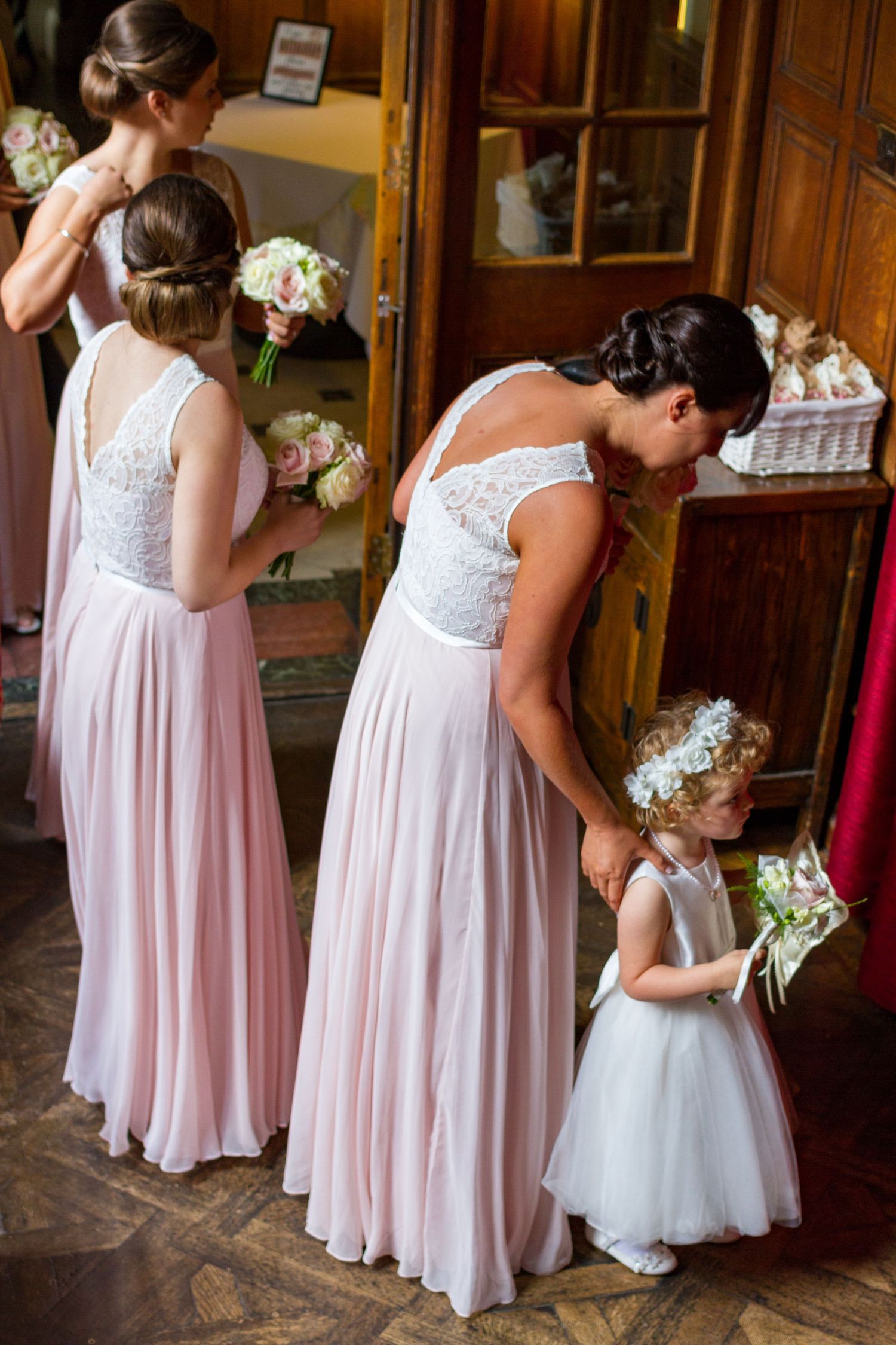 Bridesmaids and flower girl preparing for the ceremony at Gosforth Hall Hotel, sharing a quiet and heartfelt moment before walking down the