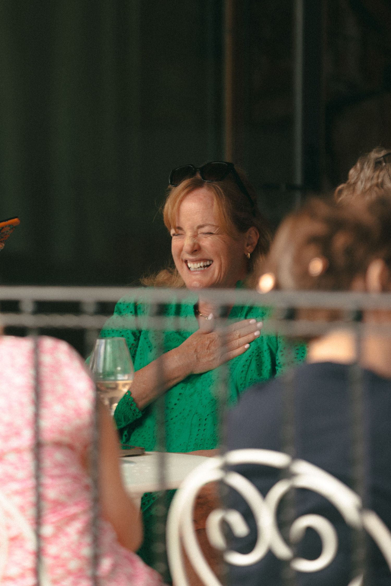 People laughing and enjoying themselves at an indoor event with green lighting.