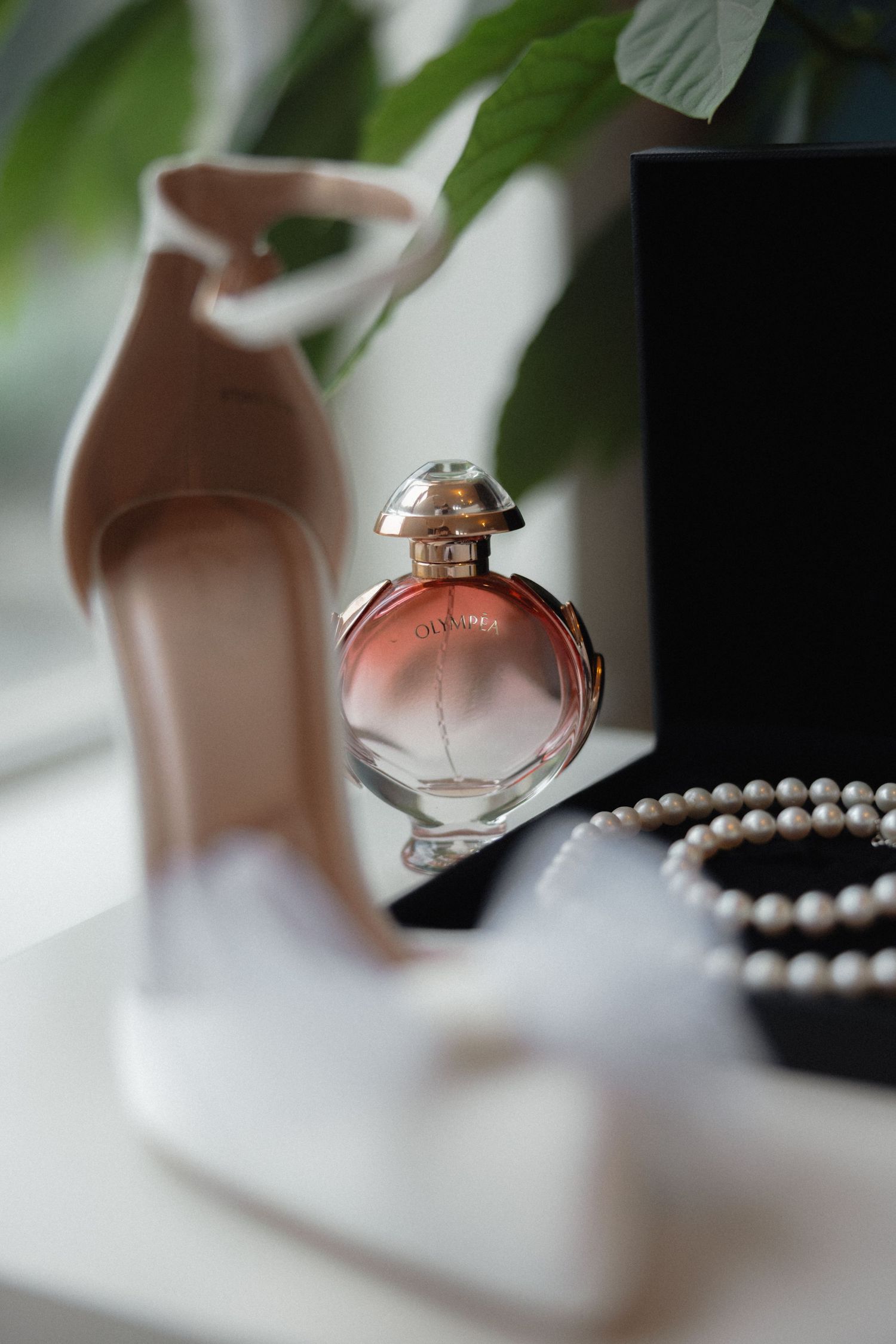 Wedding accessories with perfume bottle, pearls and high heel shoe.