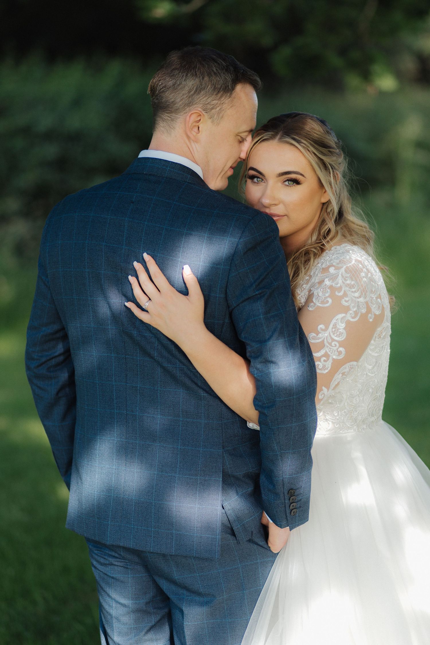 Intimate wedding portraits showing tender moments between the couple in dappled sunlight.