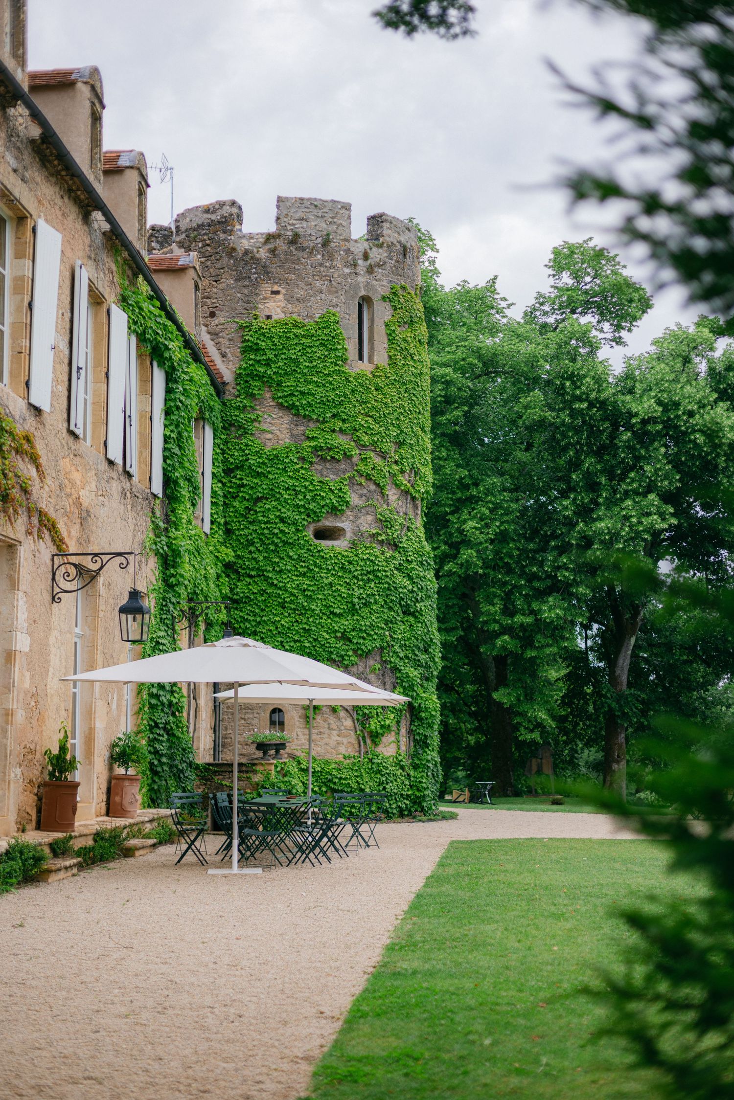 Historic castle grounds with ivy-covered walls and outdoor seating area.