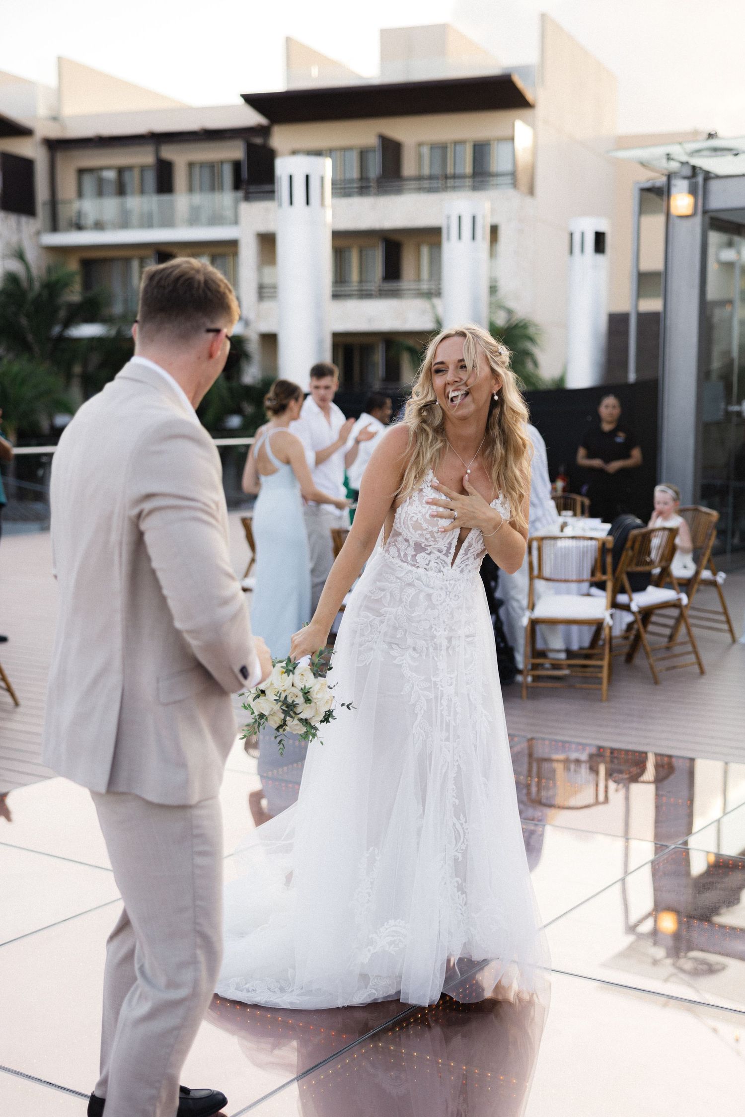 Romantic wedding dance moment captured at sunset on outdoor terrace.