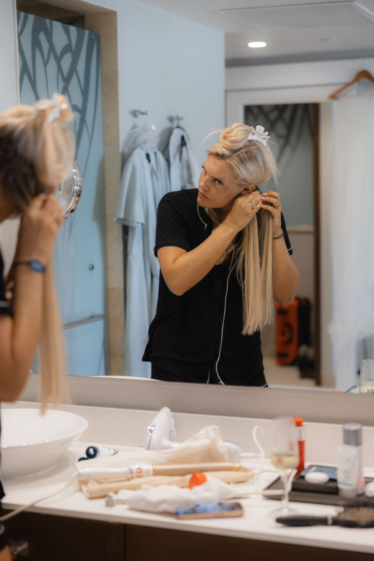 Hairstylist working with styling tools in a modern salon with mirrors.