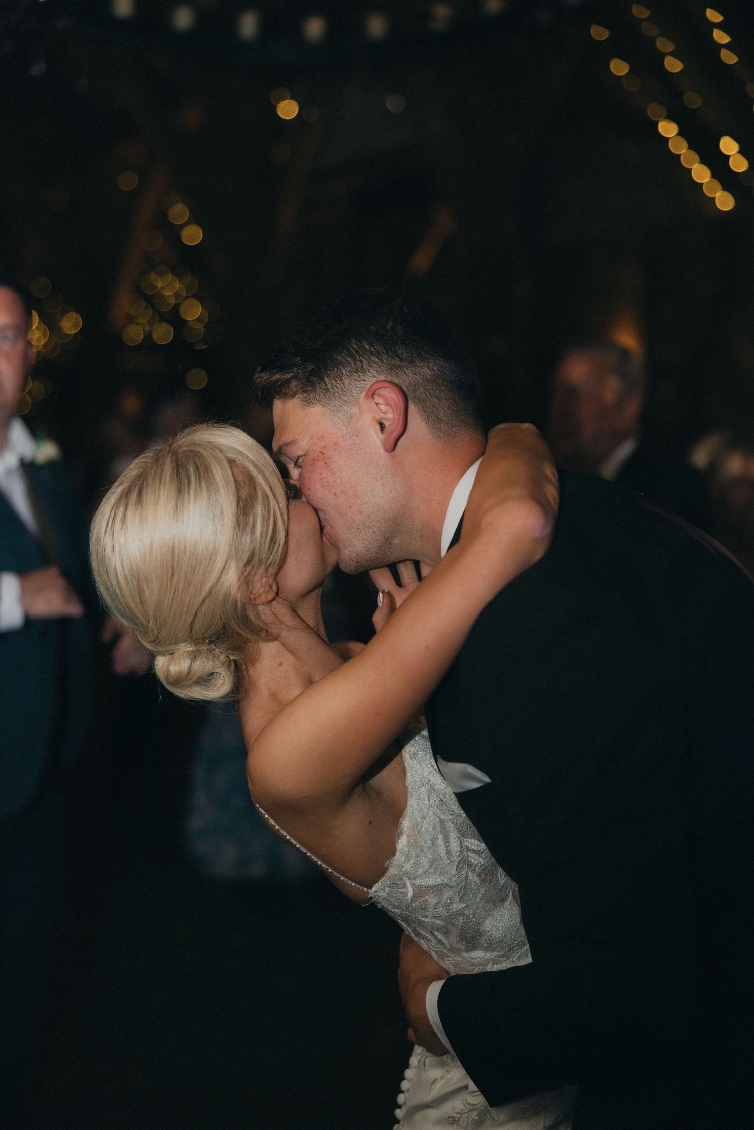 A romantic dip during a wedding dance with the bride in a white lace gown.