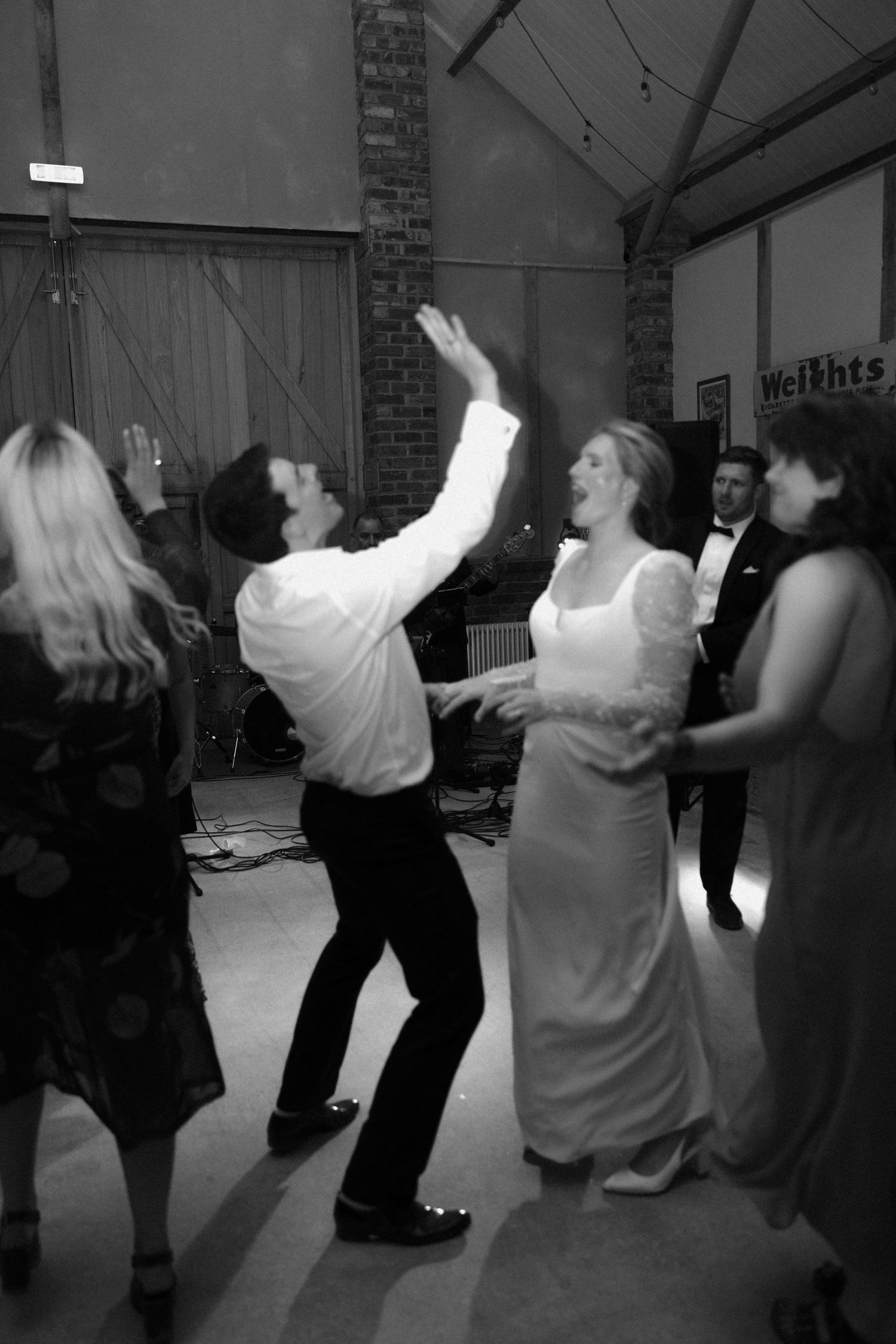 People dancing in a circle at a festive indoor celebration.