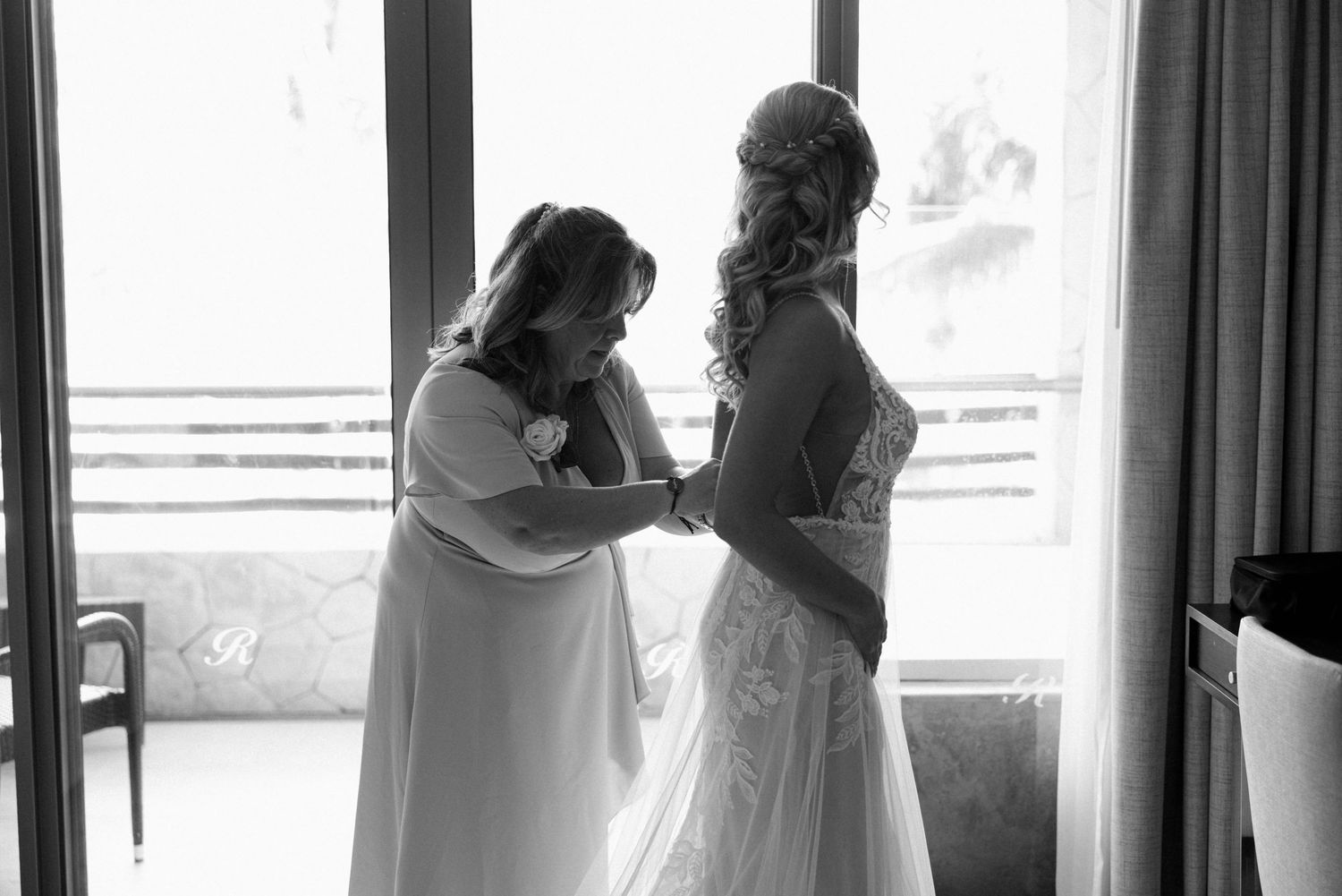 Bridesmaids in light blue dresses share emotional reactions during a wedding preparation moment.