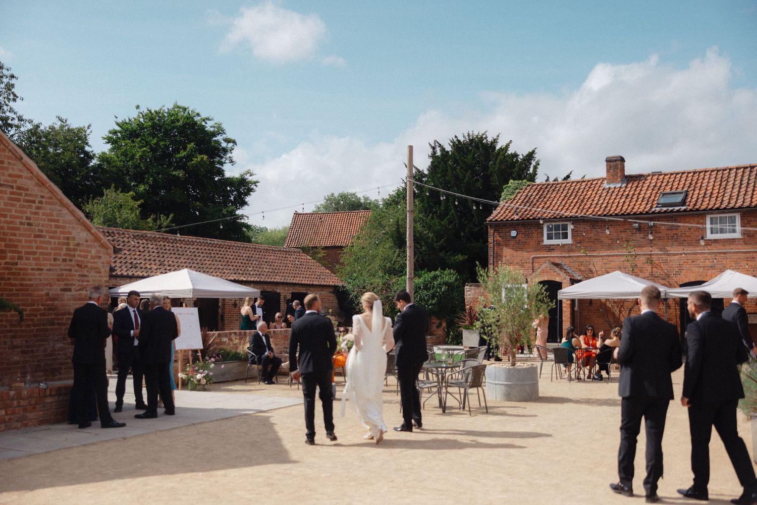 Exterior view of a rustic brick venue with guests gathering outside.