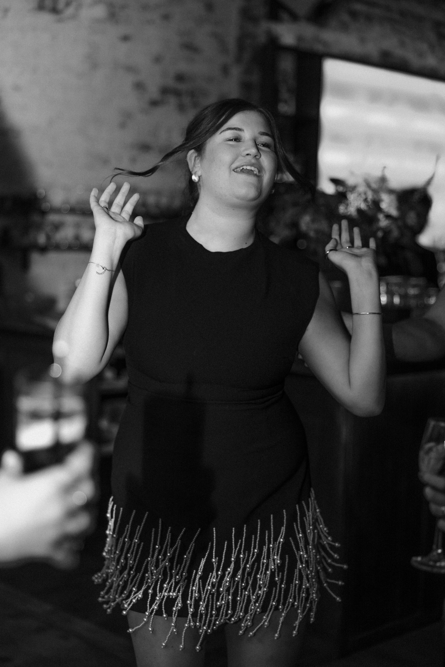 A person in black dancing joyfully at a celebration.