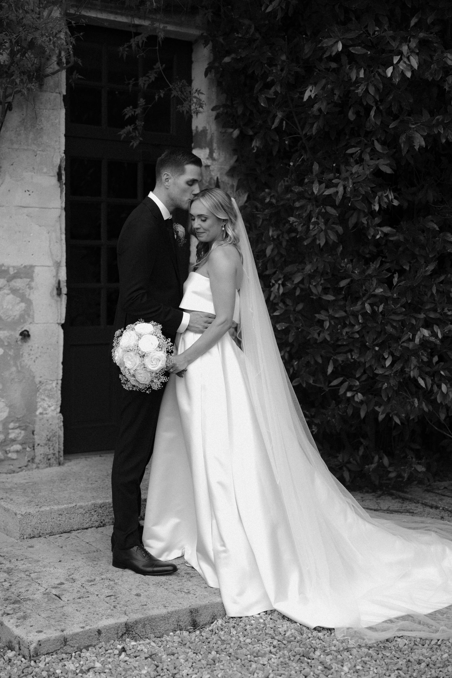 Black and white wedding portraits showing elegant bride's flowing dress train.