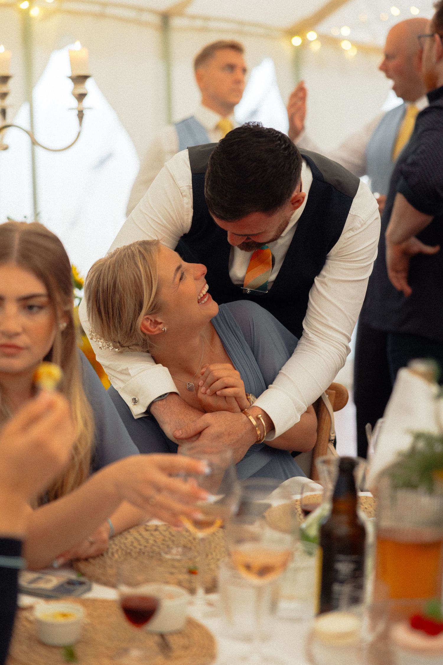 Guests share playful moment during wedding reception dinner.