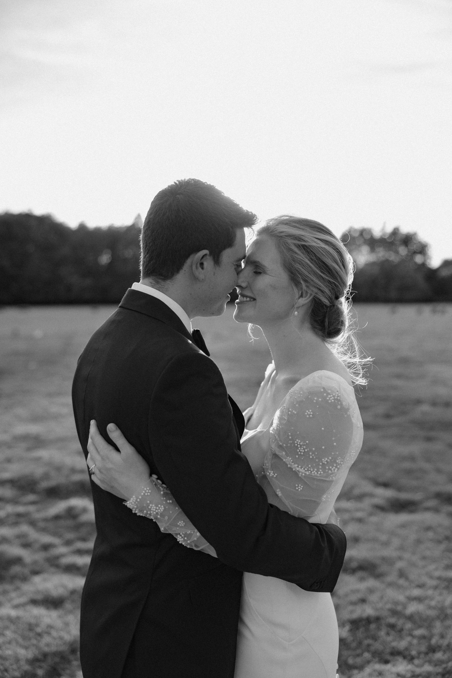 Intimate black and white portrait of wedding couple sharing tender moment.